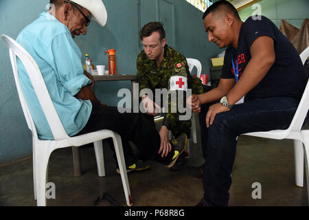 SAN PABLO, Guatemala - Kanadische Cpl. Todd Matthews, 23 Kanadische Streitkräfte Gesundheitswesen Loslösung Dundurn medizinischer Techniker, führt eine Prüfung auf Miguel Clrilel, lokale Bewohner, als Moises Velasquez, Spaß Englisch Schülerin, übersetzt, 17. Mai 2016, während der Übung über den Horizont 2016 GUATEMALA. Der Test ist, um festzustellen, ob Clrilel hat Nervenschäden und das Testergebnis negativ. Stockfoto