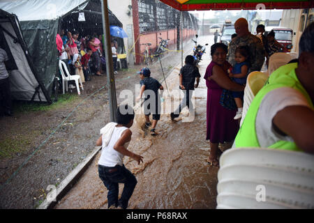 SAN PABLO, Guatemala - Drei Guatemaltekischen jungen Planschen und Spielen in der Zurückweichenden Hochwasser Mai 17, 2016, während der Übung über den Horizont 2016 GUATEMALA. Ein leistungsfähiger Sturm, Überschwemmung Bedingungen geschaffen, gestoppt Operations bei Task Force der rote Wolf medizinische Bereitschaft Übung. Stockfoto