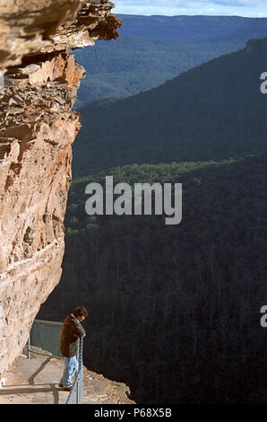 Einsame Frau auf schmalen Weg über die wichtigsten Wentforth fällt Wasserfall, Blue Mountains, New South Wales, Australien. MODEL RELEASED Stockfoto