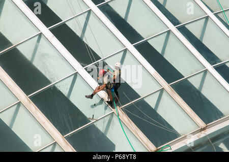 14. Oktober 2009 - Valencia, Spanien - Wartung Arbeiter mit Klettern Ausrüstung ausgestattet sind Reinigung der Glasfassade der Hemisferic. Das Gebäude ist p Stockfoto