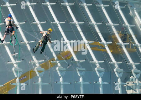 14. Oktober 2009 - Valencia, Spanien - Wartung Arbeiter mit Klettern Ausrüstung ausgestattet sind Reinigung der Glasfassade der Hemisferic. Das Gebäude ist p Stockfoto