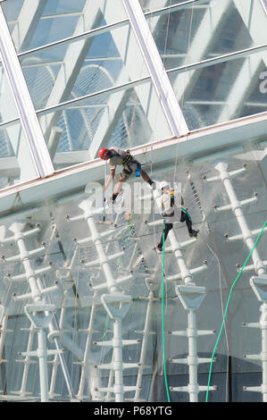 14. Oktober 2009 - Valencia, Spanien - Wartung Arbeiter mit Klettern Ausrüstung ausgestattet sind Reinigung der Glasfassade der Hemisferic. Das Gebäude ist p Stockfoto