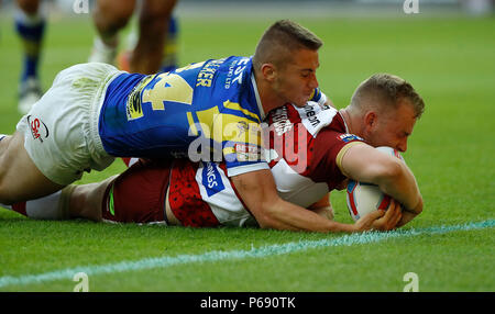 Wigan Warriors Josh Holz geht Vergangenheit Leeds Rhinos Jack Walker eine Versuchen ein Tor während der Betfred Super League match bei der DW Stadium, Wigan. Stockfoto