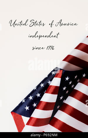 Einige amerikanische Flaggen und die Vereinigten Staaten von Amerika unabhängig seit 1776 gegen einen weißen Hintergrund Stockfoto