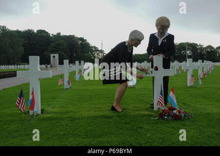 Helen Patton, Enkelin von U.S. Army, General George S. Patton, Links, Plätze, eine Rose am Grab von U.S. Army Air Corps 1. Lt Hanford 'Rusty' J. Rustand, ein B-17 Bomber Pilot im Zweiten Weltkrieg getötet, als Marilynn Rustand Lieurance, RUSTAND's Tochter, Uhren nach einem Memorial Day Zeremonie auf dem Luxemburger Friedhof und Denkmal in Luxemburg, 28. Mai 2016. Rustand starb, als sein B-17 unter feindlichem Feuer während einer Mission in der Nähe von Merseburg, Deutschland kam und an November 2, 1944 abgestürzt, fast ein halbes Jahr vor dem Lieurance war geboren. Beide Rustand und Patton's Großvater sind unter den 5,076 Ameri Stockfoto