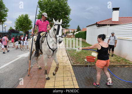 Soria, Spanien. 28 Juni, 2018. Eine Frau, die sprühwasser auf Pferd während der Feier von 'La Saca'. Die Stadt von Soria, im Norden von Spanien, feierte das 12. Jahrhundert Tradition von "La Saca', in der die Bullen, die während der eines Juan 'festival Kampf von Männern reiten Pferde aus dem "Valonsadero' mount die Stierkampfarena in der Mitte der Stadt geführt werden. Credit: Jorge Sanz/Pacific Press/Alamy leben Nachrichten Stockfoto