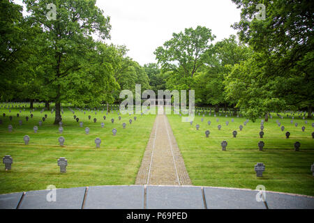 Der Deutsche Kriegsfriedhof Sandweiler in Luxemburg erinnert an 10.913 Soldaten, die während der Ardenschlacht 1944–1945 getötet wurden. Diese Stätte aus dem Zweiten Weltkrieg verfügt über Reihen einheitlicher Grabsteine und landschaftlich gestaltete Anlagen, die eine feierliche Hommage an Soldaten darstellen, die im europäischen Theater dienten. Sie wird erhalten, um die Erinnerung an Kriegsopfer zu bewahren und gibt Einblick in das Ausmaß und die Auswirkungen der Ardennenoffensive und der deutschen Militäroperationen. Stockfoto