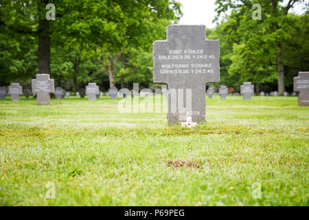 Der Sandweiler Deutsche Kriegsfriedhof im Süden Luxemburgs beherbergt 10.913 Gräber deutscher Soldaten, die während der Ardenschlacht Ende 1944 und Anfang 1945 starben. Der Friedhof verfügt über eine Reihe von Grabsteinen, ein landschaftlich gestaltetes Gelände und Gedenkmarkierungen zu Ehren des Militärdienstes und zur Erhaltung der historischen Erinnerung. Sie repräsentiert das Ausmaß der deutschen Beteiligung an der Ardennenkampagne und die Auswirkungen des Zweiten Weltkriegs in Luxemburg. Stockfoto