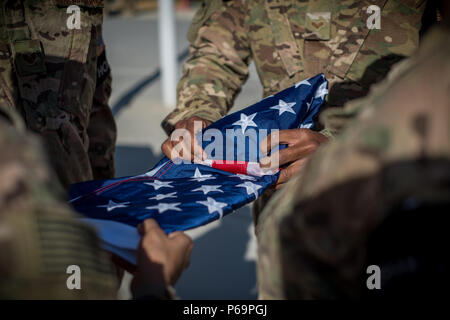 Mitglieder der Ehrengarde Team bereiten die Flagge während des Memorial Day Gedenkveranstaltung am Flughafen Bagram, Afghanistan, am 30. Mai 2016 zu falten. Memorial Day, der erstmals als Dekoration Tag bekannt wurde, wurde während des Bürgerkriegs erstellt. Im Jahre 1868 verkündet wurde von General John Logan, der nationale Kommandant der Großen Armee der Republik. Der Tag wurde ein nationaler Feiertag mit dem kongreßdurchgang Nationalfeiertag Act im Jahr 1971. (U.S. Air Force Foto von älteren Flieger Robert Dantzler) Stockfoto