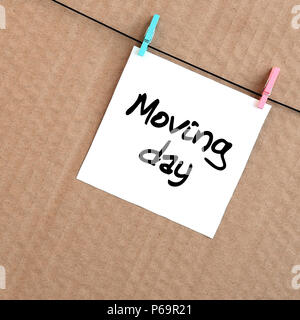 Beweglicher Tag. Hinweis befindet sich auf einem weißen Aufkleber, die mit einer Wäscheklammer an einem Seil auf einem Hintergrund von braunen Karton geschrieben. Stockfoto