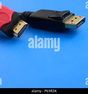 Computer Audio Video HDMI Kabel Stecker und 20-pin Stecker DisplayPort Steckverbinder, vergoldet für eine einwandfreie Verbindung auf einem blauen Hintergrund. Stockfoto