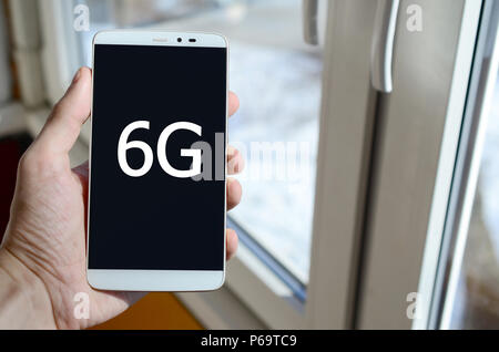 Ein Mensch sieht, ein weißer Aufschrift auf einem BlackBerry-Smartphone angezeigt werden, den er in seiner Hand hält. 6G. Stockfoto