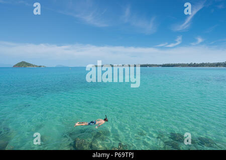 Touristen schnorcheln im kristallklaren türkisblauen Wasser in der Nähe von Tropical Resort in Phuket, Thailand. Sommer, Ferien, Reisen und Urlaub. Stockfoto