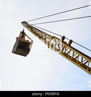 Alte gelbe mechanische Greifer Greifer auf blauen Himmel Hintergrund. Stockfoto