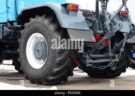 Räder der Rückansicht des neuen Traktor bei Schneewetter. Landwirtschaftliches Fahrzeug zurück. Stockfoto