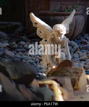 Ein Engel wacht über einen Hinterhof rock garden in der Wärme der untergehenden Sonne. Stockfoto
