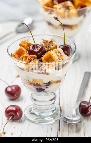 Nachtisch Waffeln, Frischkäse (Ricotta, Mascarpone, Joghurt) und frische Kirschen mit Chocolate Chips in einem Glas. Köstliches Frühstück. Wählen Sie Stockfoto