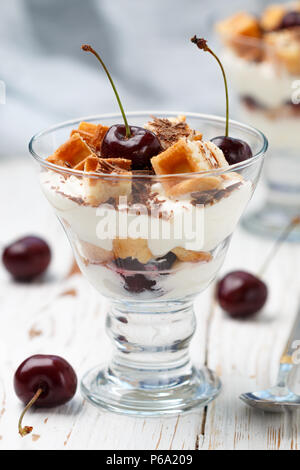 Nachtisch Waffeln, Frischkäse (Ricotta, Mascarpone, Joghurt) und frische Kirschen mit Chocolate Chips in einem Glas. Köstliches Frühstück. Wählen Sie Stockfoto