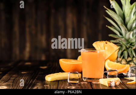Orangen- und Ananassaft mix auf Holz Hintergrund Stockfoto