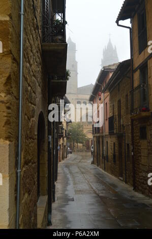 Sehr schmale Straße, wo am Ende Sehen wir die Pfarrkirche von San Andres auf einer sehr bewölkten Tag in Elciego. Architektur, Kunst, Geschichte, Reisen. De Stockfoto