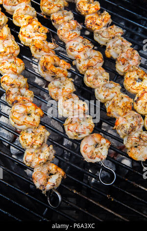 Garnelen aufgespießt und Kochen auf einem Holzkohlegrill im Freien in Südkalifornien, USA Stockfoto