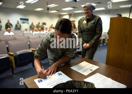 Us Air Force Master Sgt. Robin L. Wiseman, Recruiting und Retention Manager an die 180 Fighter Wing zugeordnet, Zeichen der Eid der Rekrutierung, 26. Mai 2016 Nach der Inbetriebnahme Ashleigh Jagd als Ehrenamtlicher 2. Lt in den Ohio Air National Guard während der erste Pilot für einen Tag Veranstaltung an der 180 FW. Der Pilot für einen Tag Programm ist ein Weg für die 180 FW der lokalen Gemeinschaft, indem Sie einen unterhaltsamen Tag für Kinder und junge Erwachsene leben mit chronischen oder lebensbedrohenden Krankheit oder Krankheit zu unterstützen. (U.S. Air National Guard Foto: Staff Sgt. Shane Hughes) Stockfoto