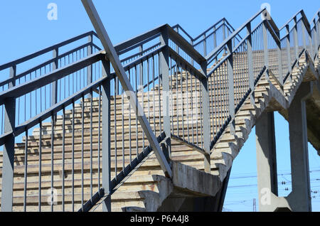 Ein Fragment eines abgestuften Aufstieg auf der Fußgängerbrücke zwischen den Plattformen der Bahnhof. Stockfoto