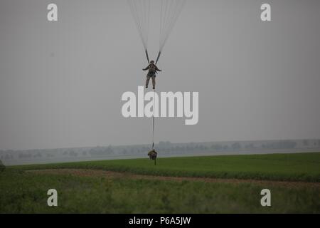 Us-Amerikanische und Deutsche Fallschirmjäger Verhalten airborne Operations aus einer C-130 Hercules während einer US/Deutschland Freundschaft Springen, Ramstein Air Force Base, Deutschland, 25. Mai 2016. Der Zweck der Freundschaft Sprung zu fördern und den US-amerikanischen und deutschen Beziehungen pflegen, entwickeln die Interoperabilität während der Ausbildung und die Grundlage für die künftige Geschäftstätigkeit um in die Zukunft in der Ausbildung und der realen Welt Umgebungen bieten. (U.S. Armee Foto von Sgt. Sergio Villafane/Freigegeben) Stockfoto