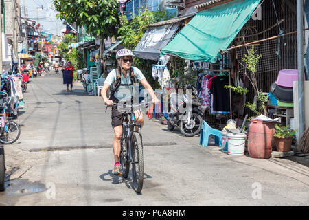 Frau Radfahren durch die Straßen in Bangkok, Thailand Stockfoto