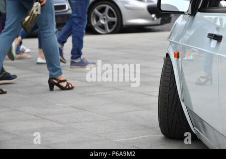 Diagonale Ansicht einer weiß-glänzend Auto, die auf einem Quadrat von grauen Fliesen steht. Stockfoto