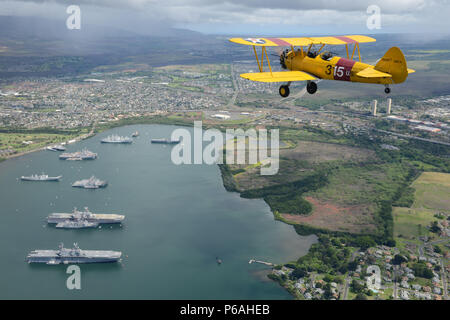 Harry Greene fliegt seine Boeing Stearman Kaydet Anfängerschulflugzeug Flugzeug über Naval inaktiv Ship Maintenance Facility in Pearl Harbor, Oahu, 30. Mai 2016. Greene ist ein Hubschrauberpilot bei Coast Guard Air Station Barbers Point und ein Flugzeug-Enthusiasten in seiner Freizeit Zeit. (Foto: U.S. Coast Guard Petty Officer 2. Klasse Tara Molle/freigegeben) Stockfoto