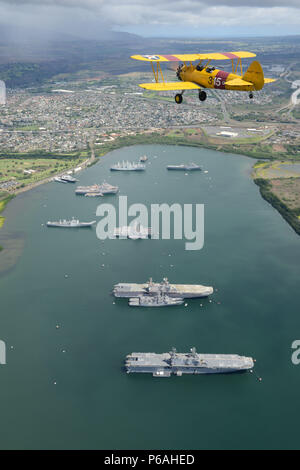 Harry Greene fliegt seine Boeing Stearman Kaydet Anfängerschulflugzeug Flugzeug über Naval inaktiv Ship Maintenance Facility in Pearl Harbor, Oahu, 30. Mai 2016. Greene ist ein Hubschrauberpilot bei Coast Guard Air Station Barbers Point und ein Flugzeug-Enthusiasten in seiner Freizeit Zeit. (Foto: U.S. Coast Guard Petty Officer 2. Klasse Tara Molle/freigegeben) Stockfoto