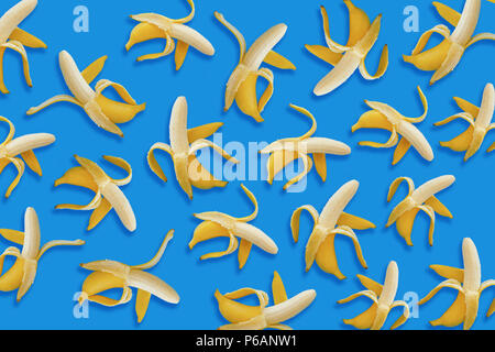 Banane Muster. Geöffnet gelbe Bananen auf blauem Papier Hintergrund, trendige Flach. Sommer Konzept Stockfoto