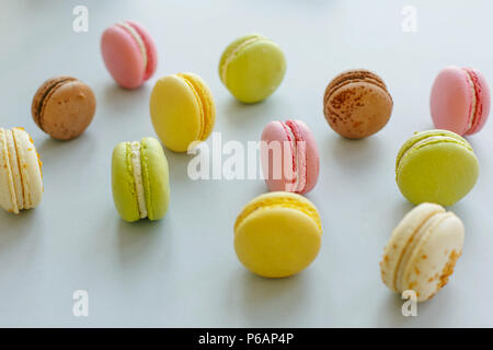 Bunte macarons am trendigen Pastellfarben grau Papier. Lecker Pink, Gelb, Grün und Braun Makronen. Candy Bar für Party. instagram Essen Fotografie. Lecker b Stockfoto