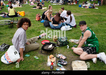 London. Hackney. London Felder. Grillfeste und Picknicks. Zwei junge Männer kochen ein Fisch auf dem Grill. Stockfoto