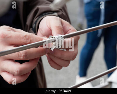 TOKYO, Japan - 28. SEPTEMBER 2017: ein Tourist, der ein schlechtes Vermögen aus dem Japanischen wahrsagen Streifen, Omikuji auswählen, seine schlechten fortune Papier binden mit einer Stange im Sensoji-tempel zu verlassen, Asakusa Stockfoto