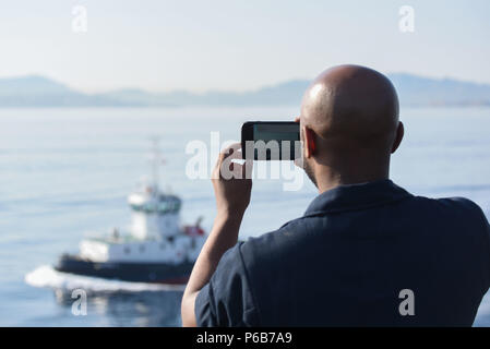 180621-N-EA 818-0068 MARSEILLE, Frankreich (21. Juni 2018) Aviation Support Equipment Techniker 2. Klasse Willie Smith Fotos als Nimitz-Class Flugzeugträger USS Harry S. Truman (CVN 75) Ansätze der Pier. Harry S. Truman ist derzeit als Teil eines laufenden Rotation der US-Streitkräfte unterstützen Maritime Security Operations in internationalen Gewässern rund um den Globus eingesetzt. (U.S. Marine Foto von Mass Communication Specialist 2. Klasse Thomas Gooley/Freigegeben) Stockfoto