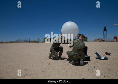 Meteorologie und Ozeanographie Analyst forecast Marines mit Distanz ein, Marine Air Control Squadron 24, Marine Air Control Gruppe 48, 4 Marine Flugzeugflügel, bereiten ein wetterballon von der taktischen Atmospheric Sounding Kit zu lösen, während integrierte Ausbildung Übung 4-18 bei Marine Corps Air Ground Combat Center Twentynine Palms, Calif., 21. Juni 2018. METOC Marines mit Marine Air Ground Task Force 23 96 Stunden Wettervorhersagen und die vorhergesagten Auswirkungen auf Ausbildung, Truppe oder Flugbewegungen, oder die Benutzung von nachtsichtbrillen. (U.S. Marine Corps Foto von Lance Cpl. Samantha Schwoch/ Stockfoto