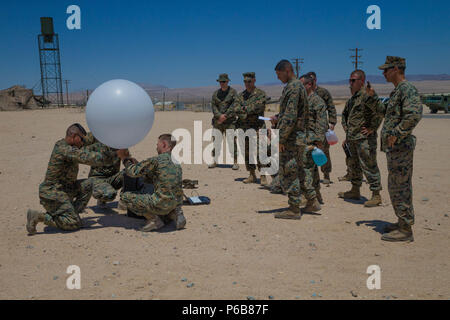 Meteorologie und Ozeanographie Analyst forecast Marines mit Distanz ein, Marine Air Control Squadron 24, Marine Air Control Gruppe 48, 4 Marine Flugzeugflügel, bereiten ein wetterballon von der taktischen Atmospheric Sounding Kit zu lösen, während integrierte Ausbildung Übung 4-18 bei Marine Corps Air Ground Combat Center Twentynine Palms, Calif., 21. Juni 2018. METOC Marines mit Marine Air Ground Task Force 23 96 Stunden Wettervorhersagen und die vorhergesagten Auswirkungen auf Ausbildung, Truppe oder Flugbewegungen, oder die Benutzung von nachtsichtbrillen. (U.S. Marine Corps Foto von Lance Cpl. Samantha Schwoch/ Stockfoto