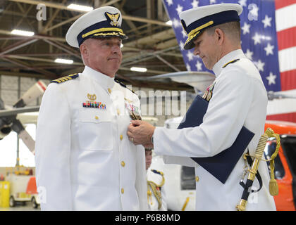 Hintere Adm. Matthew T. Bell Jr., der Kommandant der 17 Coast Guard Bezirk, präsentiert Kapitän Mark Morin, kommandierender Offizier der Air Station Kodiak, mit einem Meritorious Service Medal, die während eines Befehls Zeremonie im Hangar 3 am Air Station Kodiak, Alaska, 22. Juni 2018. Kapitän Mark Morin übertragen Befehl zum Kapitän Bryan Dailey während einer offiziellen Zeremonie, die formelle Übertragung der Autorität und Verantwortung von einem Offizier zu einem anderen. U.S. Coast Guard Foto von Petty Officer 1st Class Charly Hengen. Stockfoto