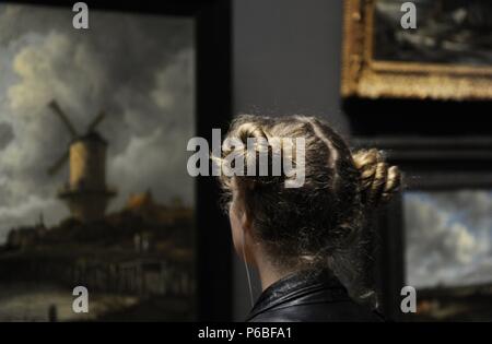 Holland. Amsterdam. Rijksmuseum. Junge Frau auf der Suche nach einem Isaackz Jakob van Ruisdael (C. 1628-1682) Malen die Mühle von Wijk bij Duurstede, C. 1668-1670. Stockfoto