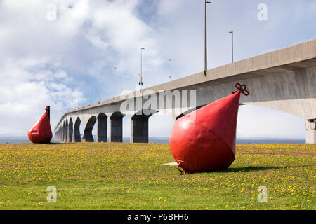 Riesige rote Metall Bojen auf dem Rasen vor der acht Kilometer lange Confederation Bridge, dass links Prince Edward Island und New Brunswick, Kanada. Stockfoto