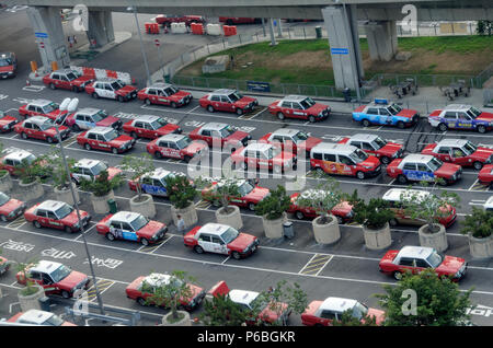 Taxis Queuing in Zeilen Kunden von der Ankunftshalle des Flughafens auf der Insel von der Stadt (rot Kabine) oder auf Kowloon (blau) Stockfoto