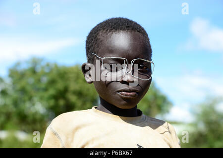 UGANDA, Karamoja, Kaabong, Dorf Lochom, Karamojong Stamm, Junge mit Kabel Spezifikationen/Junge mit Drahtbrille Stockfoto