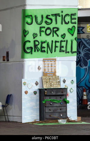 Der erste Jahrestag des 24-stöckigen Hochhauses Grenfell von Sozialwohnungen wohnungen Feuer, das 72 Menschenleben gefordert. Gerechtigkeit für Grenfell Schild in der Nähe ein provisorisches Denkmal unter den Westway Überführung. South Kensington, London, UK, 14. Juni 2018. Stockfoto