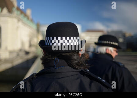 Nahaufnahme von zwei weiblichen Bobby Polizisten auf Patrouille in den Straßen von London Stockfoto