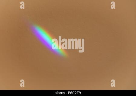 Lichtpunkte auf Putz. Foto von Rainbow Labs auf beige Wand. Stockfoto