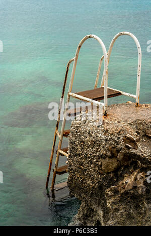 Ein Metall aus Leitern in die Felsen an der Küste installiert Badegäste in das und aus dem klaren Mittelmeer zu unterstützen. Stockfoto