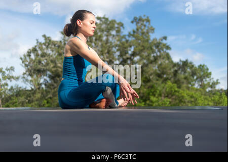 Weibliche meditieren, Yoga sitzen draußen in der Sonne Stockfoto