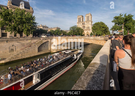 Paris, Frankreich, 24. Juni 2018: Traditionelle Bateau Mouche Boot auf dem Fluss Seine und Notre-Dame Kathedrale im Hintergrund Stockfoto